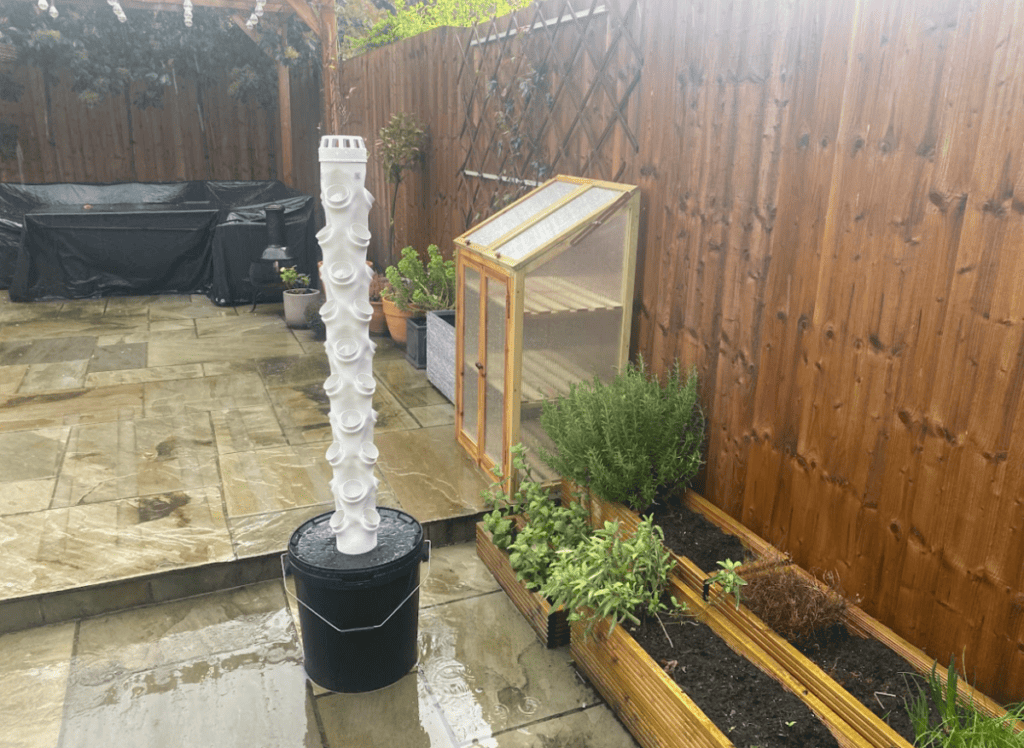 A white hydroponic tower garden outside in the